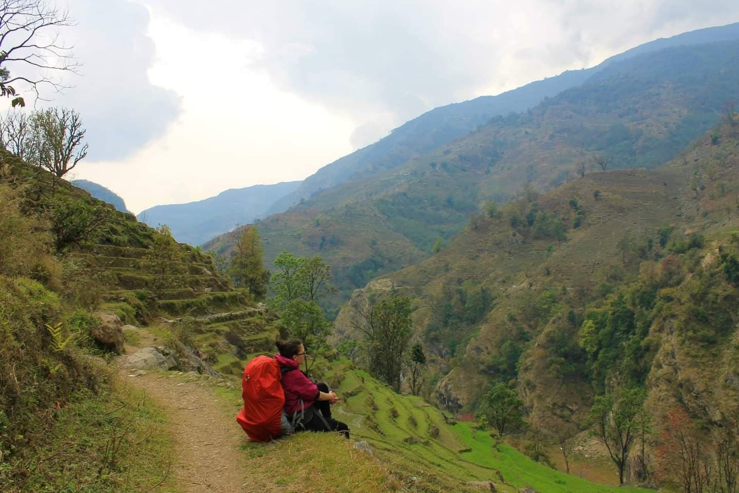 Trekker resting on a green hillside