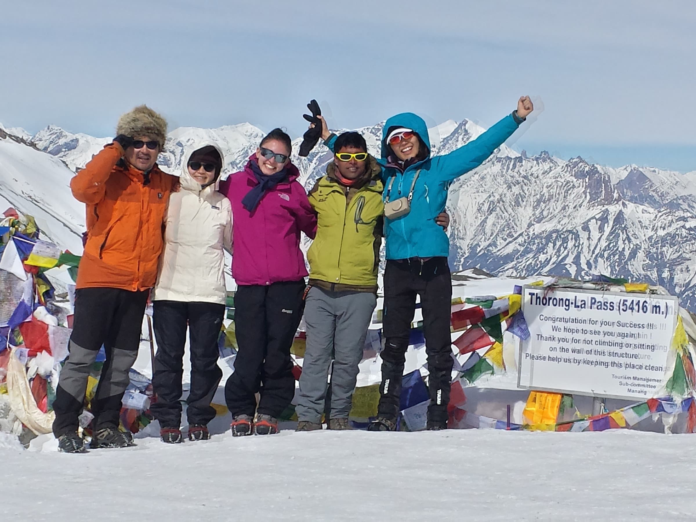Trekking group celebrating at Thorong La pass