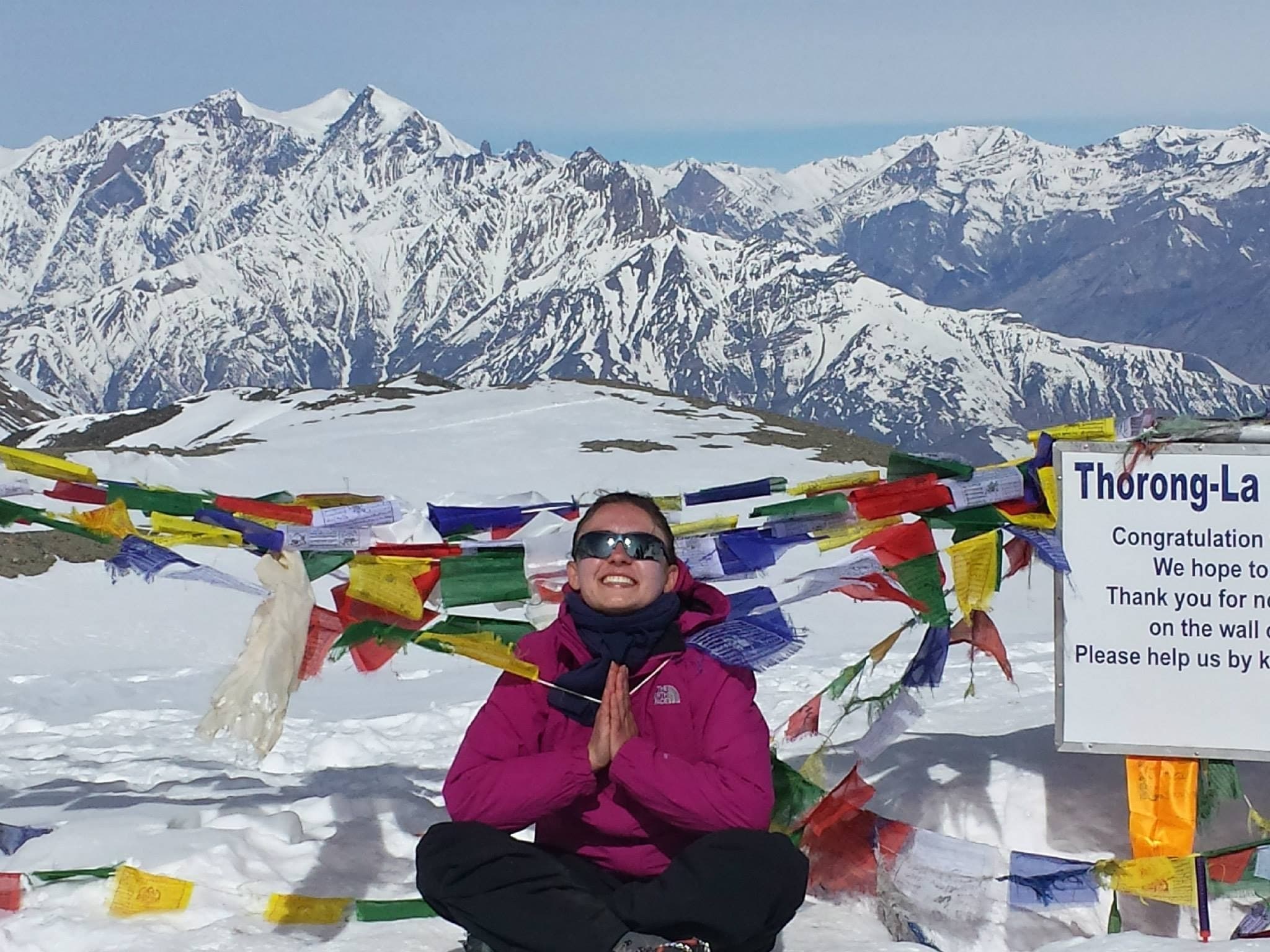 Elis meditating among prayer flags at Thorong La pass, 5,416 m